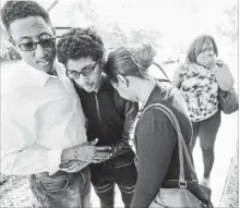  ?? WILFREDO LEE THE ASSOCIATED PRESS ?? Family members embrace after a student walked out from Marjory Stoneman Douglas High School, Wednesday, in Parkland, Fla. The shooting sent students rushing into the streets.