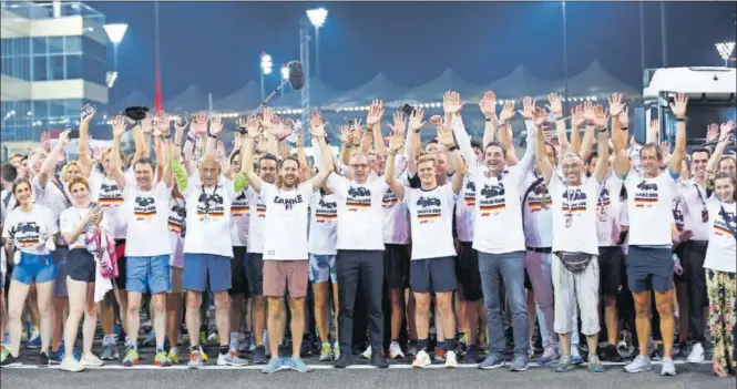  ?? ?? ‘Seb’ posa en la pista del circuito de Yas Marina rodeado del personal del ‘paddock’, vestidos con camisetas en las que se lee ‘Gracias Vettel’, tras dar una vuelta al trazado.