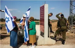  ?? (Reuters) ?? WOMEN hold flags near the West Bank community of Tekoa. The new American ambassador to Israel supports Israel’s policies.