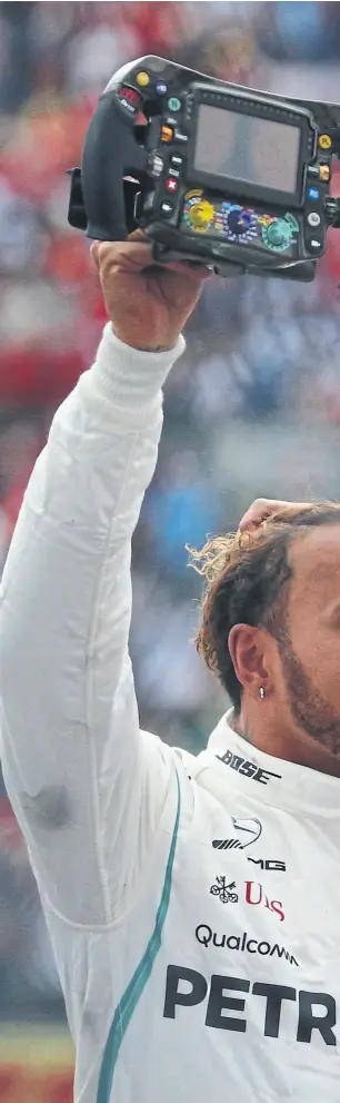  ??  ?? con el volante de su mercedes en la mano, Hamilton celebra su quinto título mundial