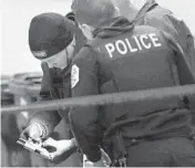  ?? TERRENCE ANTONIO JAMES/CHICAGO TRIBUNE ?? Chicago police recover a gun at a crime scene in the alley between Euclid Avenue and Bennett Avenue at 81st Street in Chicago after a reported shooting on March 5.