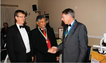  ?? Photo: Supplied ?? Ismail Mahomed is congratula­ted by Geoff Antrobus, incoming President of the Rotary Club of Grahamstow­n, with Rotarian Gavin Keeton, who read out the citation.