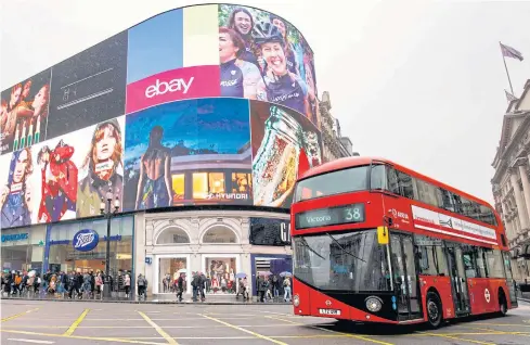  ?? AFP ?? A red double-decker bus goes past Piccadilly Circus advertisem­ent screens in London in this photo taken on October 26, 2017.