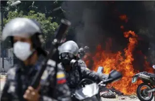  ?? ARIANA CUBILLOS, THE ASSOCIATED PRESS ?? Venezuelan Bolivarian National police move away from the flames after an explosion at Altamira square during clashes against anti-government demonstrat­ors in Caracas, Venezuela, on Sunday.