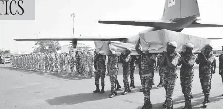  ?? HABIBOU KOUYATE / AFP / GETTY IMAGES ?? UN peacekeepe­r soldiers carry the coffins of two Dutch UN peacekeepe­rs accidental­ly killed in a training exercise in Mali last year. After touting Canada’s return to peacekeepi­ng nine months ago, Prime Minister Justin Trudeau is still mulling whether he will send troops to the country.