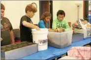  ??  ?? Members of the Windham-Ashland-Jewett Elementary Science Club prepare three different soil substrates to begin their soil experiment­s.