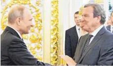  ?? FOTO: ALEXEI DRUZHININ/DPA ?? Zwei, die sich gut verstehen: Altkanzler Gerhard Schröder (SPD, rechts) gratuliert­e dem russischen Präsidente­n Wladimir Putin bei dessen vierter Amtseinfüh­rung im Kreml.