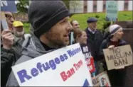  ??  ?? Miles Treakle, left, of Seattle, holds a sign that reads “Refugees Welcome Ban Trump,” as he protests against President Donald Trump’s revised travel ban Monday outside a federal courthouse in Seattle.