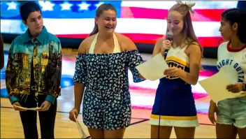  ?? PHOTO VINCENT OSUNA ?? Brawley union high school cheerleade­r elysse landy (middle, left) reads a letter she wrote to be included in a care package for military members during a special ceremony Wednesday night at the Buhs gymnasium in Brawley.
