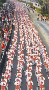  ?? — AFP ?? Indonesian dancers perform the traditiona­l poco- poco dance along the streets of Jakarta.