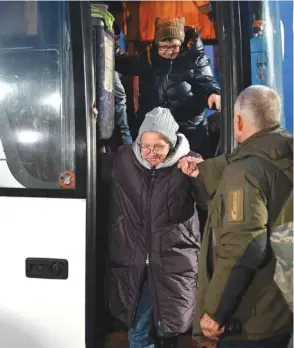  ??  ?? Former Ukrainian prisoners walk out of a bus following a prisoner exchange between Ukraine and pro-Russian rebels near the Mayorsk checkpoint yesterday.