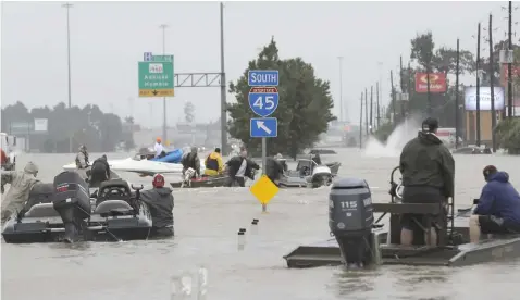  ?? (AP) ?? Volunteer rescue boats make their way into a flooded subdivisio­n to rescue stranded residents as floodwater­s from Tropical Storm Harvey rise Monday, August 28, in Spring, Texas.