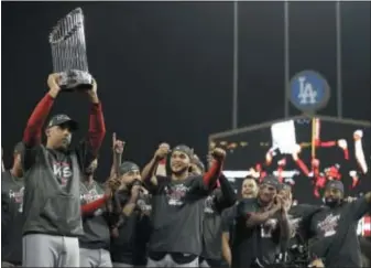  ?? THE ASSOCIATED PRESS ?? Boston Red Sox manager Alex Cora holds the championsh­ip trophy after Game 5 of the World Series against the Los Angeles Dodgers. The Red Sox won the series 4 games to 1.