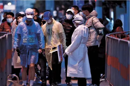  ??  ?? Shanghai marathon runners go through temperatur­e and health code checks before the start of the race yesterday. Competitor­s had to pass a coronaviru­s test to take part in the marathon and were ordered to wear a mask before and after the race.
— Dong Jun