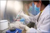  ??  ?? A staff member conducts an inspection in the COVID-19 vaccine quality inspection laboratory on Oct 15.