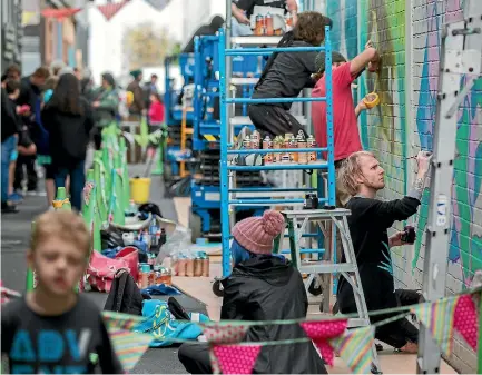  ?? PHOTO: MURRAY WILSON/ FAIRFAX NZ ?? Artists work their magic on the walls of Berrymans Lane.