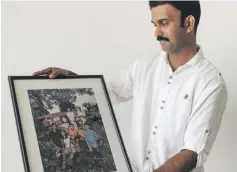  ??  ?? Jomy Joseph receives his family portrait Waleed Shah and Nikith Nath