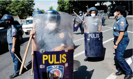  ?? Reuters ?? Police officers prepare to block demonstrat­ors from marching near the Philippine Internatio­nal Convention Center during a rally on Friday in Metro Manila.