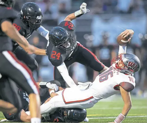  ?? Steph Chambers/Post-Gazette ?? Upper St. Clair’s Colin McLinden knocks back West Allegheny quarterbac­k Kam Kruze as he stretches for extra yards Friday at Upper St. Clair High School.