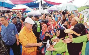  ??  ?? RAKYAT Johor setia menunggu ketibaan baginda biarpun hujan lebat.