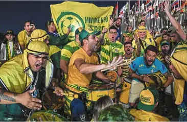  ?? — AFP ?? Start the music: brazil fans dance and cheer as they gather at the Flag Plaza in doha.