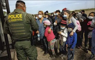  ?? Carolyn Cole Los Angeles Times ?? YOUNG ASYLUM SEEKERS wait in La Joya, Texas, for U.S. Border Patrol agents to bus them to processing facilities last month, when a record of nearly 19,000 minors were detained as they crossed the border alone.