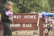 ?? Jessica Christian / Hearst Media ?? A woman leaves a bouquet of flowers at a memorial Saturday following the deadly shooting of three female Pathway Home employees by a former resident at Yountville Veterans Home of California on Friday in Yountville, Calif.
