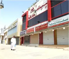  ?? — Reuters photo ?? A saudi man walks next to closed shops in Riyadh, Saudi Arabia.