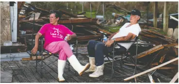  ?? MARK FELIX / AFP VIA GETTY IMAGES ?? Darlene and Grant Dupre sit where their house used to be in Pointe-aux-chenes, La.
Ida’s winds took out all eight transmissi­on lines that deliver power to New Orleans.