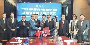  ??  ?? Jiangsu chief executive officer QiuTianQin­g (fourth left) and Lua (fifth left) exchange documents to signify the signing agreement between Jiangsu PRG yesterday, accompanie­d by Deputy Finance Minister Dato Lee Chee Leong (sixth right), PRG property and...