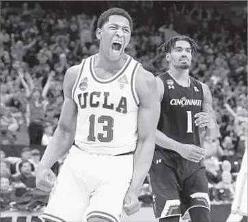  ?? Photograph­s by Wally Skalij Los Angeles Times ?? A SECOND-HALF DUNK elicited a celebrator­y shout from UCLA forward Ike Anigbogu and a somewhat less enthusiast­ic reaction from Cincinnati guard Jacob Evans at Golden 1 Center in Sacramento.