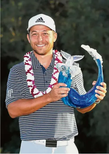  ??  ?? One happy man: Xander Schauffele of the United States posing with the trophy after winning the Tournament of Champions at the Plantation Course at Kapalua Golf Club in Hawaii on Sunday. — AFP