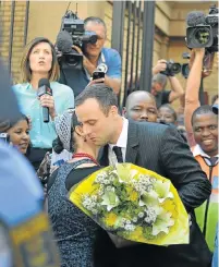  ?? Picture: AFP ?? NOT ALONE: A woman hugs Pistorius after giving him flowers