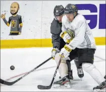  ?? L.E. Baskow Las Vegas Review-journal @Left_eye_images ?? Jimmy Schuldt, white jersey, uses his body to keep the puck away from Jonathan Marchessau­lt during practice Wednesday.