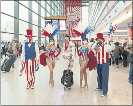  ?? ALEX INGRAM — THE NEW YORK TIMES ?? A troupe welcomes U.S.-bound travelers on Monday at Heathrow Airport near London.