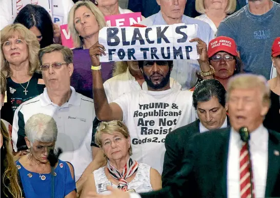  ?? PHOTO: REUTERS ?? Michael the Black Man stands behind President Donald Trump as the president speaks to a crowd at the Phoenix Convention Centre.