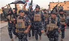  ?? FADEL SENNA, AFP/GETTY IMAGES ?? Members of the Iraqi federal police celebrate in the Old City of Mosul on Monday after the government announces the “liberation” of the embattled city. Islamic State group fighters had held control of Mosul since June 2014.