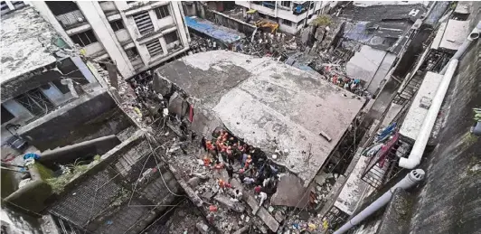  ?? —AP ?? Search for life: Rescuers looking for survivors after the residentia­l building collapsed in Bhiwandi.