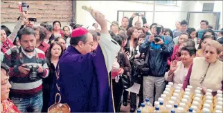  ?? JAIME MARÍN / EXPRESO ?? Feligreses. El arzobispo Marcos Pérez bendice la chicha y los panes que se consumirán en el acto religioso.