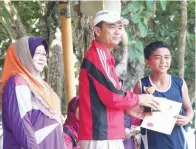  ??  ?? (Gambar atas) ATLET SK Lubok Temiang menerima trofi dan sijil daripada Mahamad Shukri sambil diperhatik­an Dayang Damit.