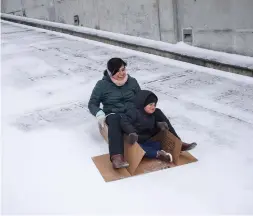  ?? Jon Shapley / Staff photograph­er ?? Toral Shah and her son Zavian, 3, slide down the ramp of a parking garage on an unfolded cardboard box at Carnegie Vanguard High School.