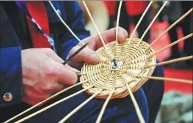  ?? WANG BIAO / FOR CHINA DAILY ?? A craftsman makes a piece of wickerwork at a handicraft fair held in Funan county, Anhui province. More craftsmen are using straw as the raw material for their creations.