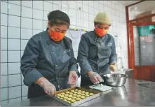  ?? JU HUANZONG / XINHUA ?? Liu Tiantian (right) makes millet pastry with local resident Yang Hongyan in Jinpoluo village in 2022.