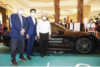  ?? ?? Megaworld Lifestyle Malls Head Graham Coates (left), PGA Cars Planning Director Christophe­r Chan (middle) and Transporta­tion Secretary Jaime Bautista pose with the fully electric Porsche Taycan.