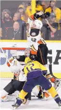  ?? MARK HUMPHREY/ASSOCIATED PRESS ?? Anaheim’s Josh Manson (42) leaps to bat away the puck during the third period in Nashville on Thursday.