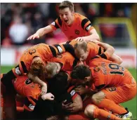  ??  ?? PILE UP: Dundee United players celebrate Mark Durnan’s winning goal