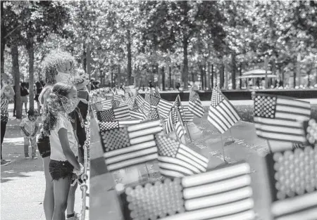  ?? BRITTAINY NEWMAN/THE NEW YORK TIMES ?? People gather at the 9/11 Memorial in lower Manhattan during the Fourth of July on Saturday in New York.