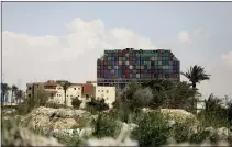  ?? MOHAMED ELSHAHED — THE ASSOCIATED PRESS ?? The 1,300-foot-long vessel loaded with cargo containers towers over nearby buildings.