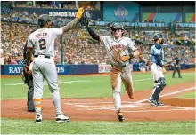  ?? AP-Yonhap ?? San Francisco Giants’ Lee Jung-hoo, center, celebrates with teammate Jorge Soler, left, after scoring during the first inning of an MLB game against the Tampa Bay Rays in St. Petersburg, Fla., Sunday.