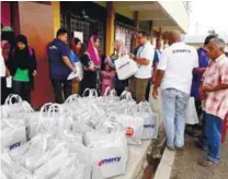  ??  ?? Mercy Malaysia personnel distributi­ng essential items to the victims.